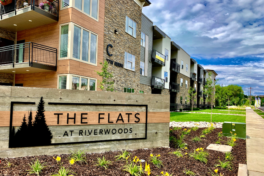 Flowerbed and main signage in front of The Flats at Riverwoods in Provo, UT.