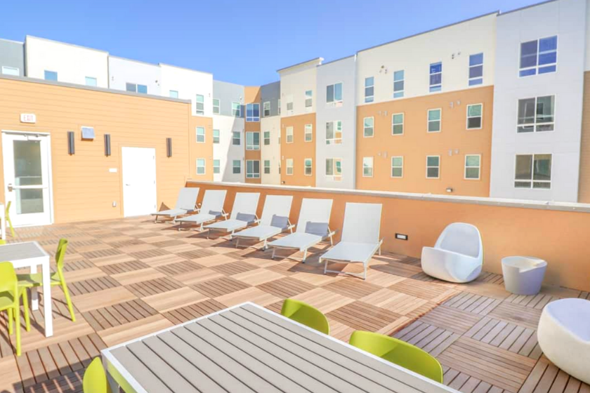 Sunbathing deck with lounge chairs and tables at The Green on Campus Drive at UVU.