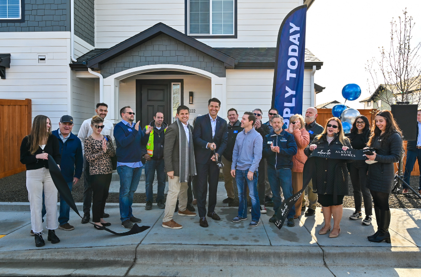 Happy residents and PEG team members gathered in front of a beautiful Alante Home at Lake Hazel community